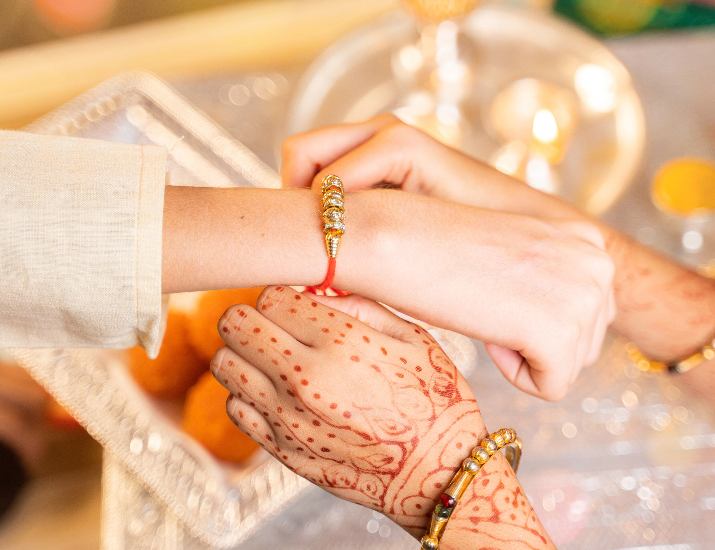 Close-up of a sister tying rakhi on brothers hand
